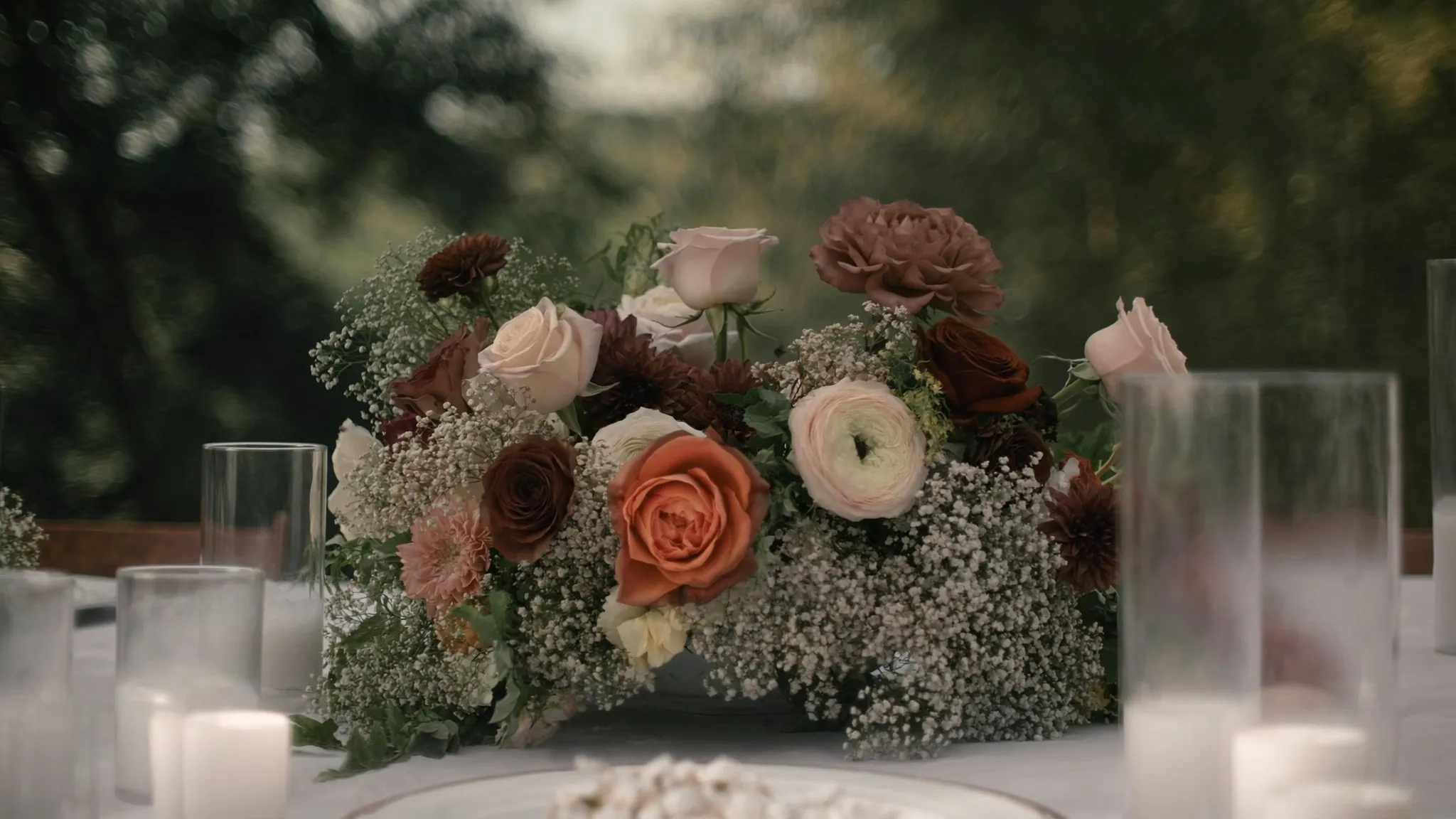A lush wedding centerpiece of garden roses, ranunculus and baby's breath