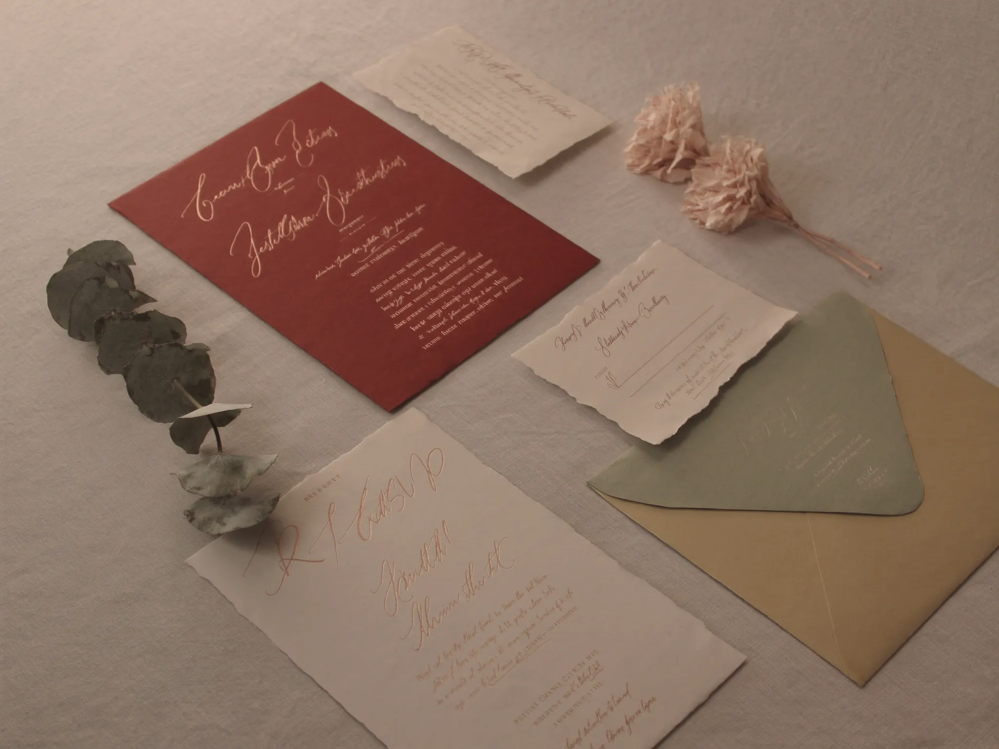 Wedding invitations, RSVP cards and envelopes with eucalyptus on linen