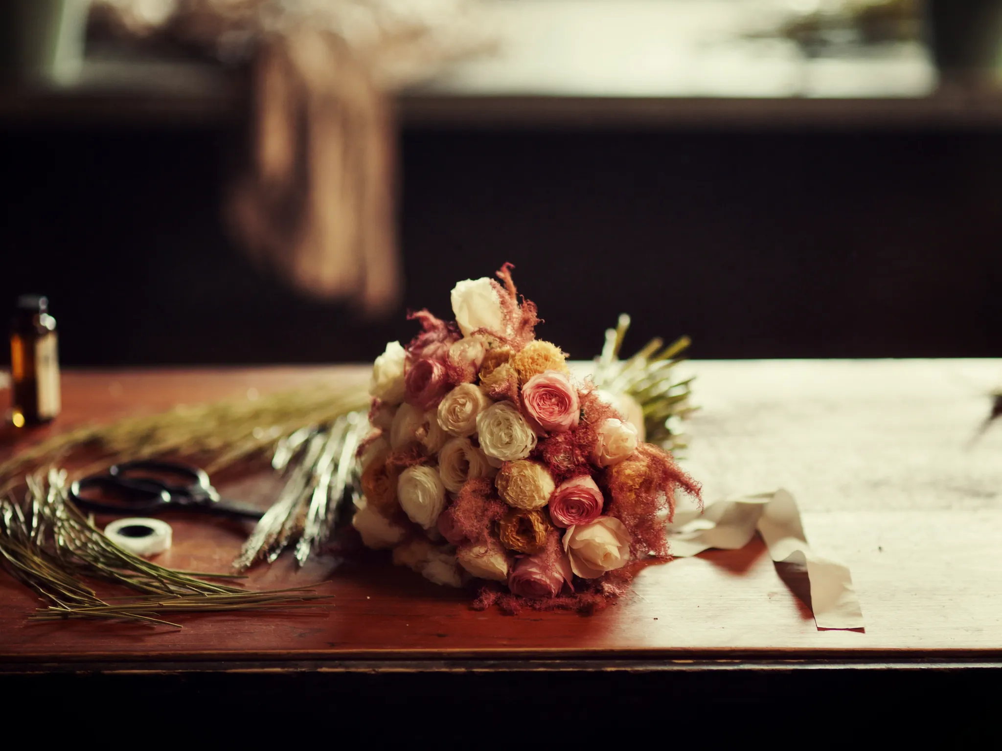 A bridal bouquet of garden roses on a florist's workbench
